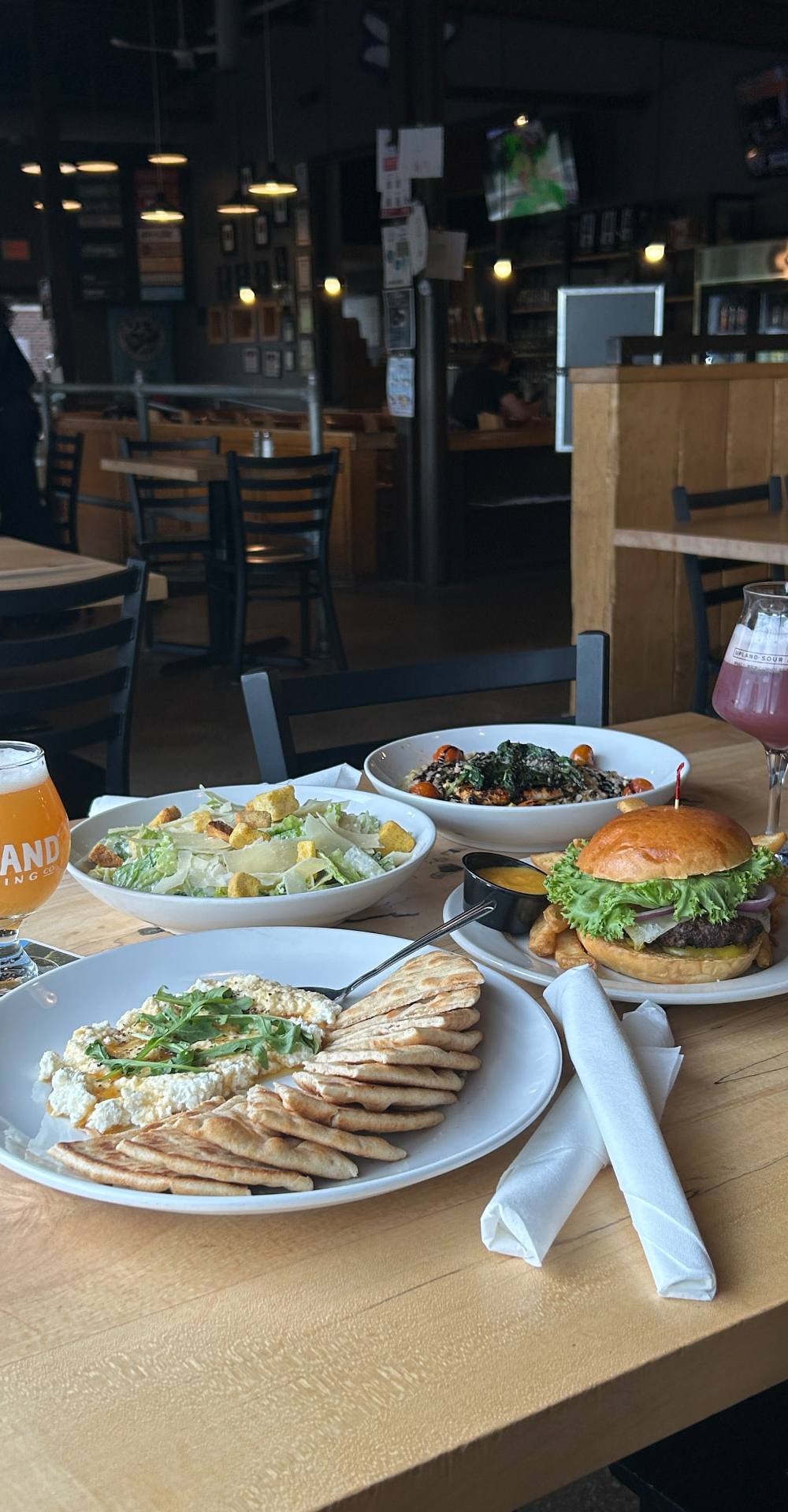 A table spread of Upland food and beer at the Bloomington Brewpub